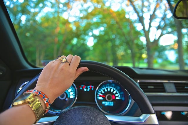 A women's hand on a steering wheel