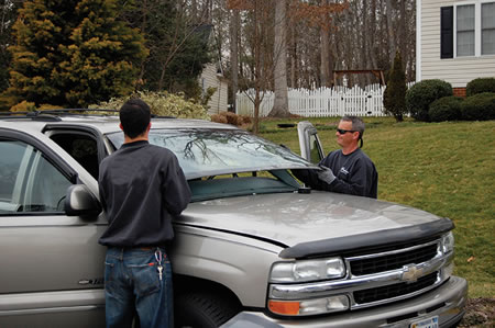 two person performing a windshield replacement