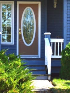 A brown front door with an oval window.
