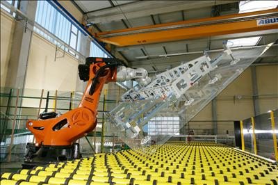 A machine arm holding a flat piece of glass.