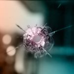 bullet resistant glass with a bullet hole in it.