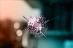 bullet resistant glass with a bullet hole in it.