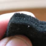 Black felt being held by two fingers.