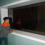 A child sitting in front of two-way glass.