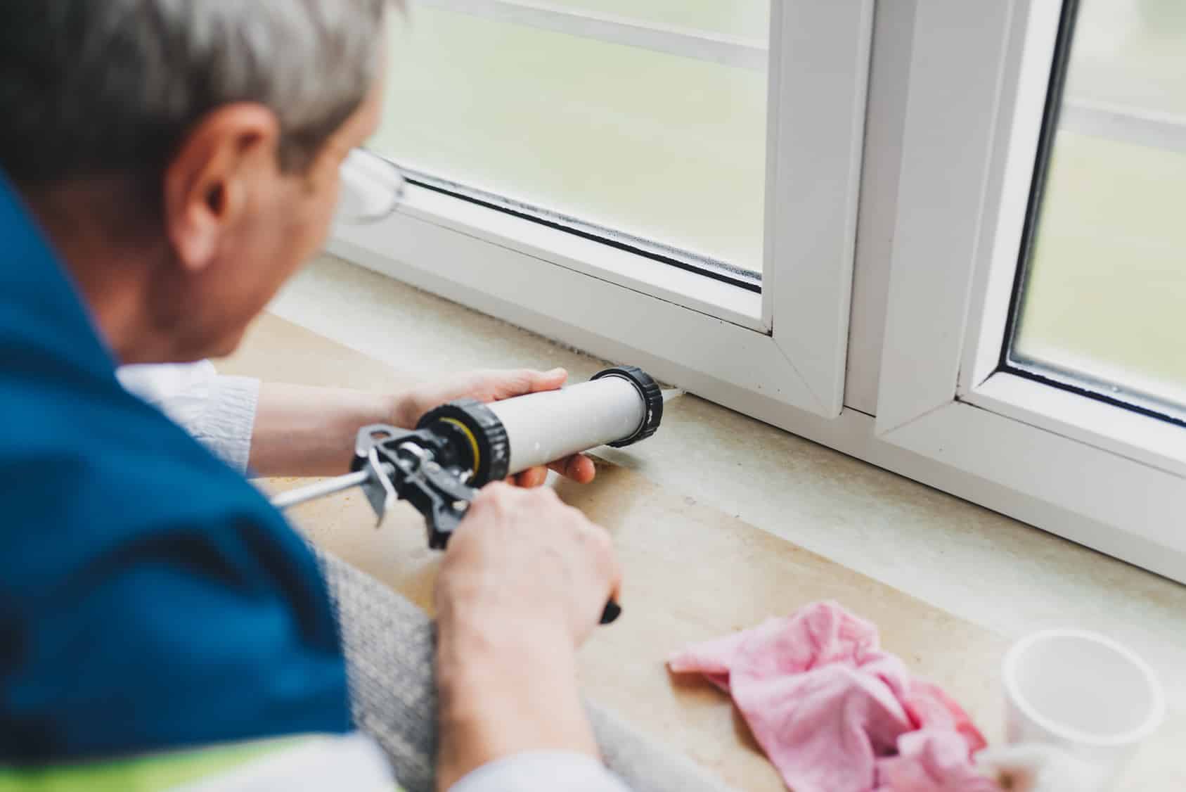 Man caulking a window