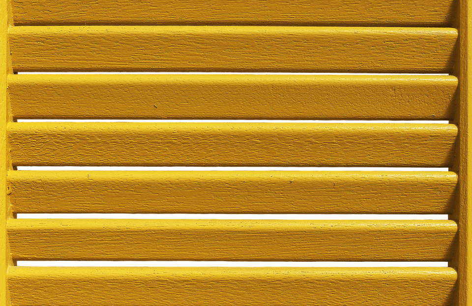 A close up of a light brown window shutter.