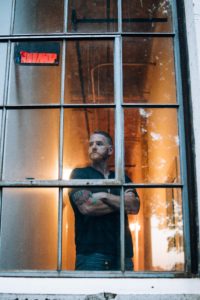 Dustin Anderson standing behind glass window
