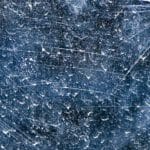 A scratched piece of glass with water spots.