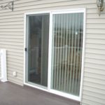 An outside look of a glass, patio sliding door.