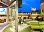 Glass pivot doors lead from inside to an outdoor patio.