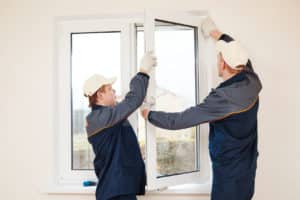 Two guys installing a window.