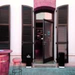Two large hinged doors are open, leading to an opened glass door, into a restaurant.