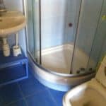 Round shower with a glass door.