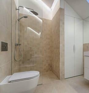 A clean, simple bathroom. In the bathroom with a glass door shower, a white toilet, and a white vanity.