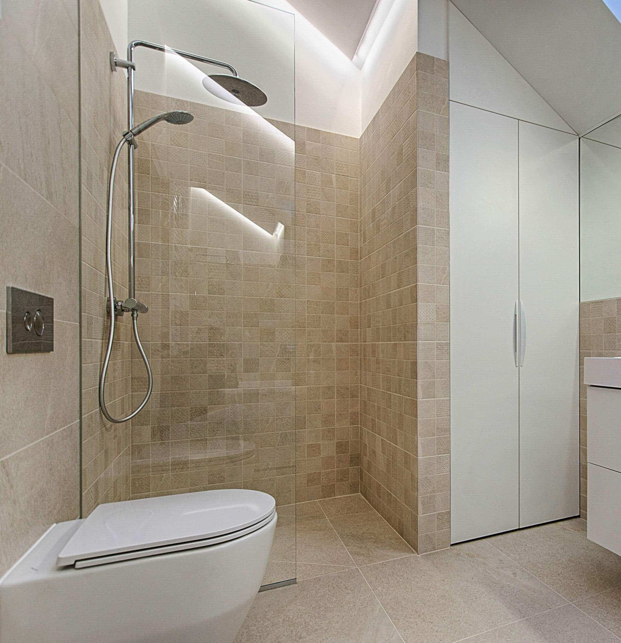 A clean, simple bathroom. In the bathroom with a glass door shower, a white toilet, and a white vanity.