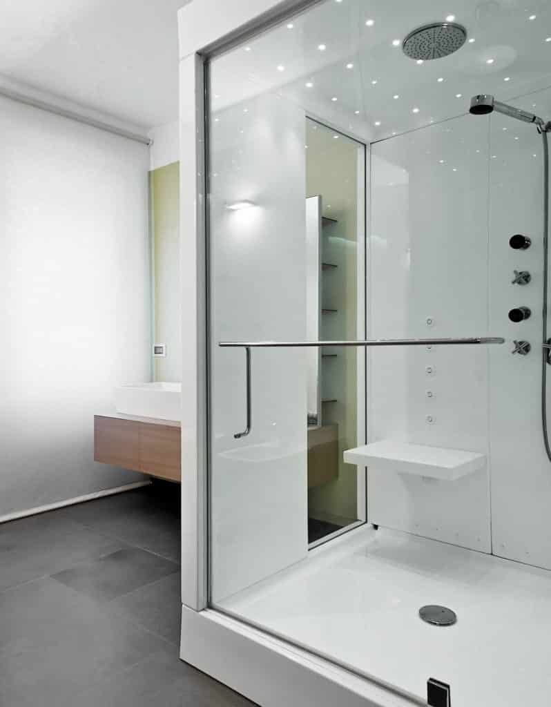 A glass, sliding shower door. Has a horizontal, silver handle in the middle of the door.