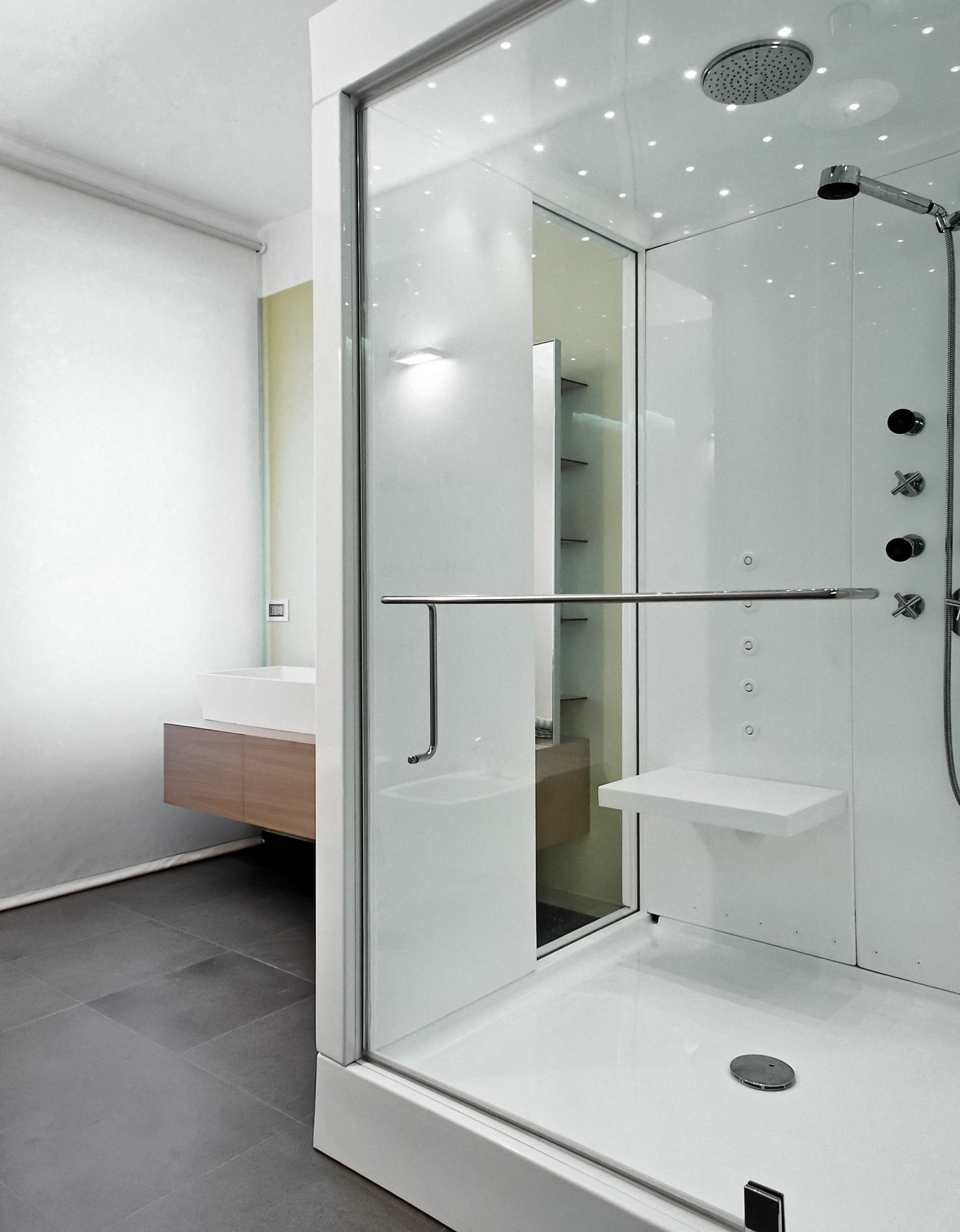 A glass, sliding shower door. Has a horizontal, silver handle in the middle of the door.