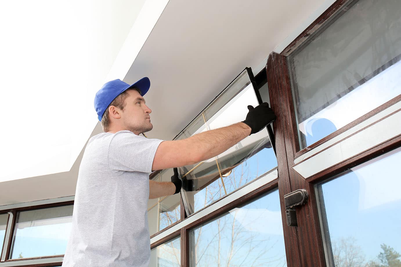 Construction worker repairing window in house