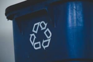 A blue recycle bin with white arrows pointing at one another to form a triangle.