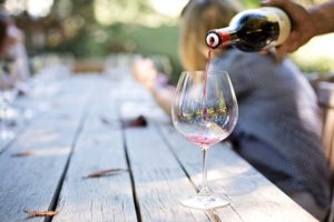 large red wine glass being filled with red wine.