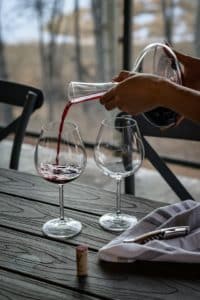 red wine aeration being poured into two wine glasses