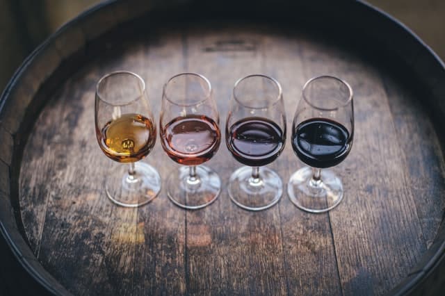 A top view of four wine glasses filled with four different wines