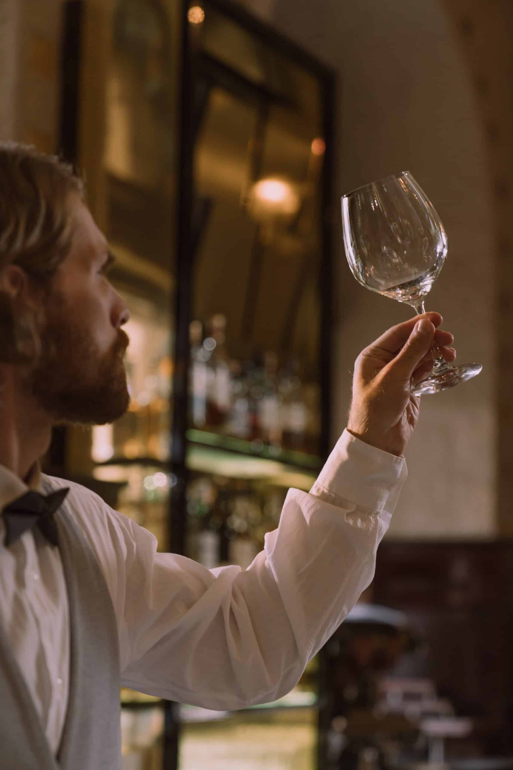 wine glass clarity being inspected by a man.