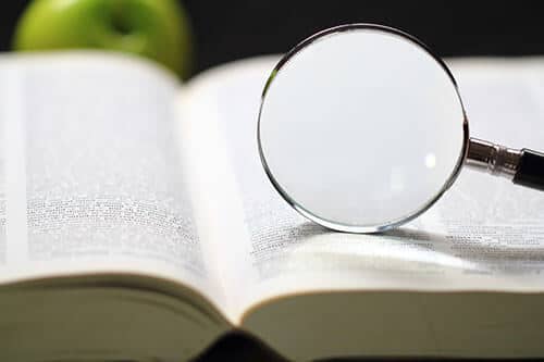 Glass Magnifying glass sits up on an open book