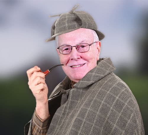 Olderman with glasses smile a the camera dressed as a detective with a hat and coat. Is holding a smoke pipe in one of his hands.