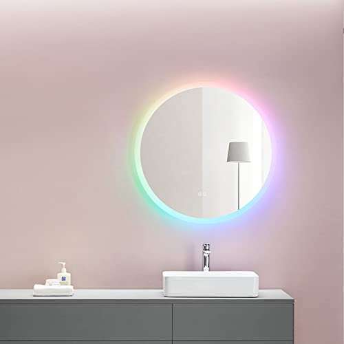 Circle mirror hanging on a pink bathroom wall with a rainbow ring around the mirror. The mirror has a lamp reflection in it and a bathroom sink sitting under it.