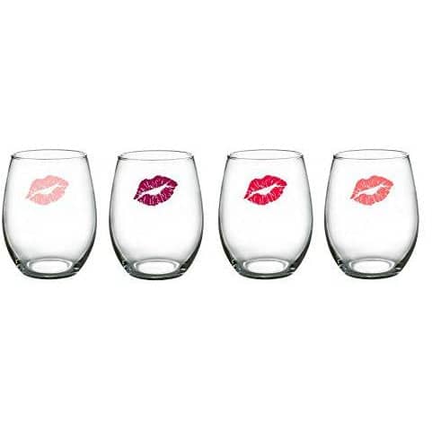Four stemless wine glasses with lip prints on the front of each one with various colors of red and pink