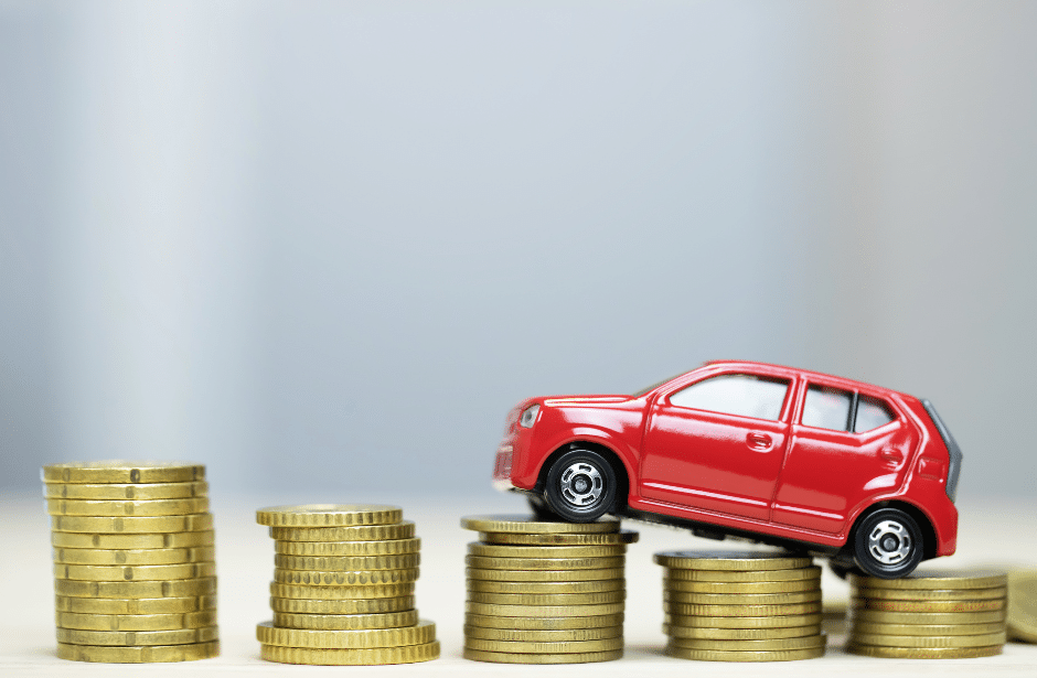 Car on stacks of coins signifying the costs of windshield replacement stacking up if you do not take care of yourself.