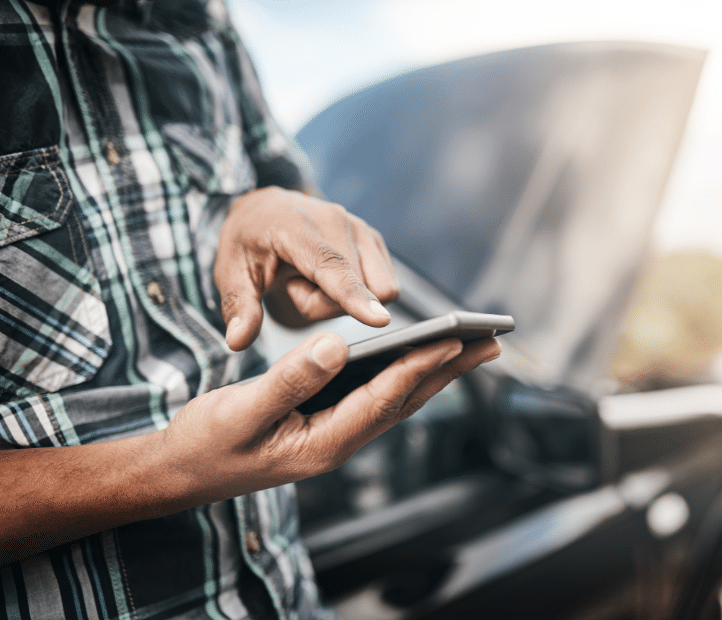 man calling roadside assistance when his vehicle a need for emergency auto glass replacement in a crisis.